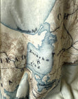 Close-up of a textured fabric with a map design featuring water bodies and landforms.